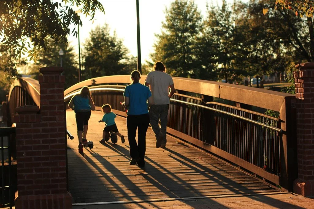 Hábitos saludables. Caminar. Familia paseando al atardecer